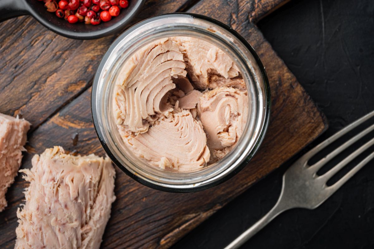 canned-tuna-fillet-meat-in-olive-oil-on-black-background-flat-lay